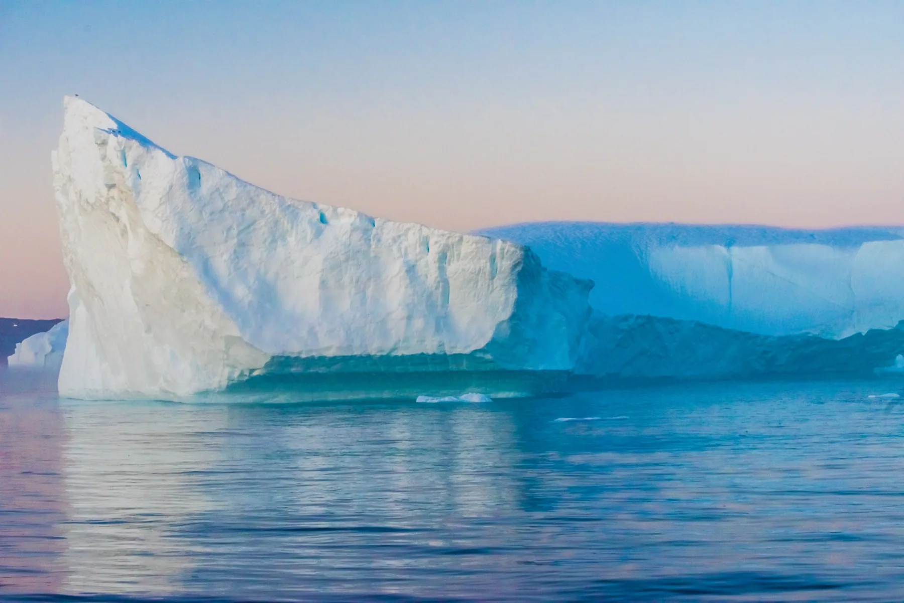 Monumental iceberg reflected in calm Arctic water