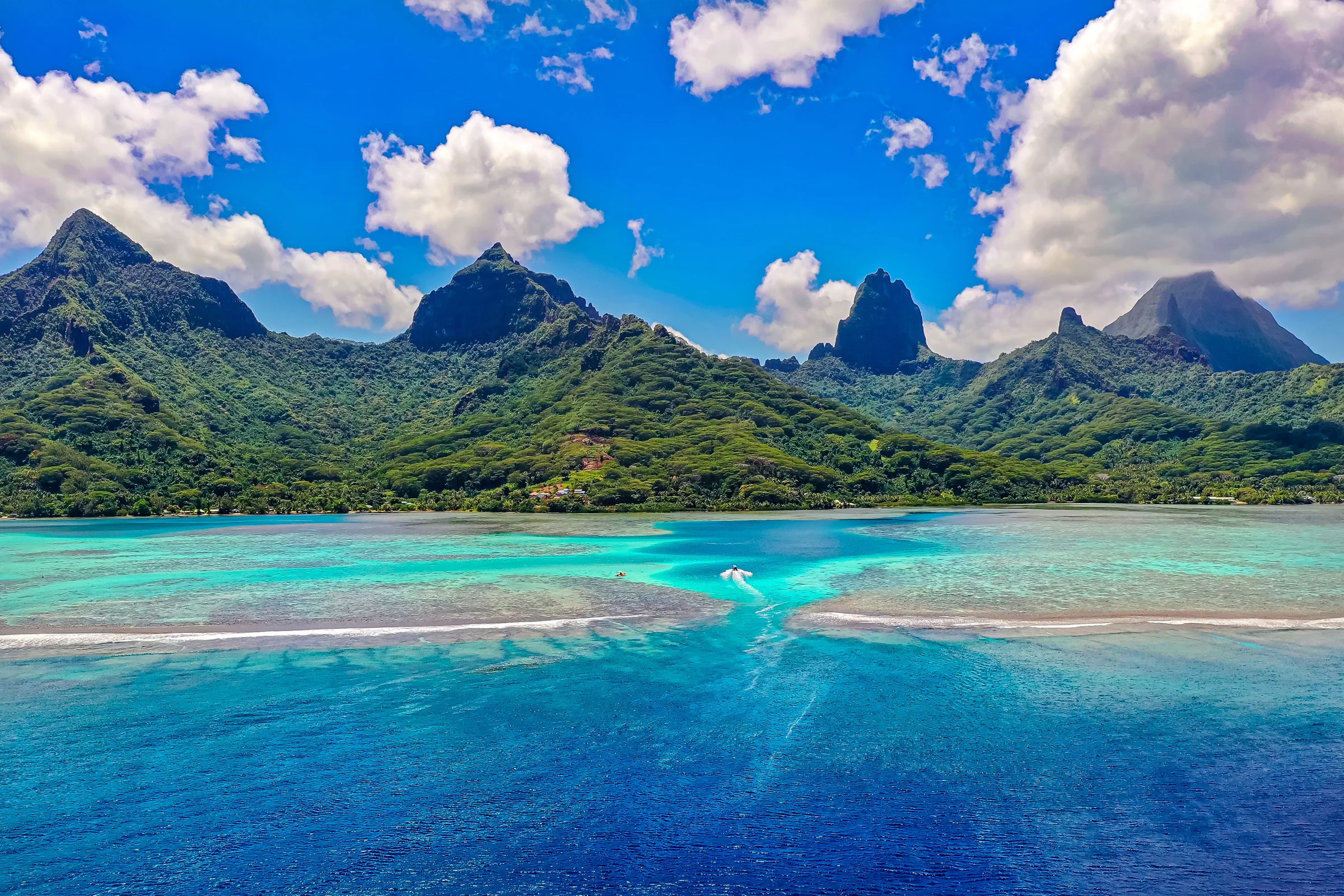 Mountainous Pacific island rising above a turquoise lagoon